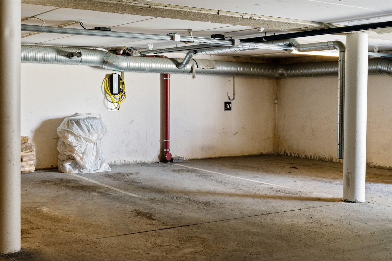 Parkeringsplass i oppvarmet p-kjeller med elbil lader. Galleribilde