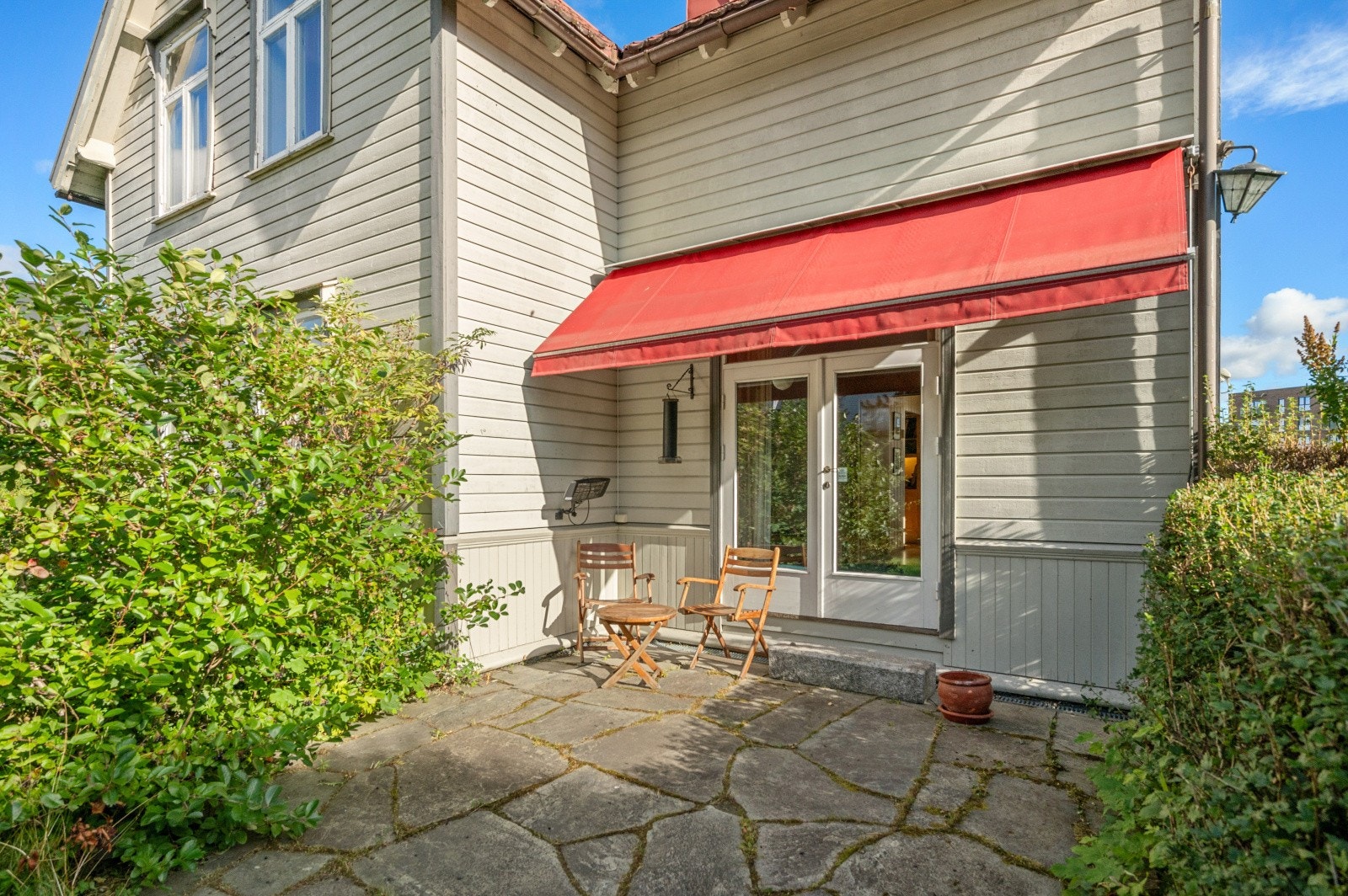 Dobbeldør fra stue til koselig skiferterrasse som ble lagt i 2010. Eiendommen har sol store deler av dagen og det er etablert markise med utgang fra stue Galleribilde