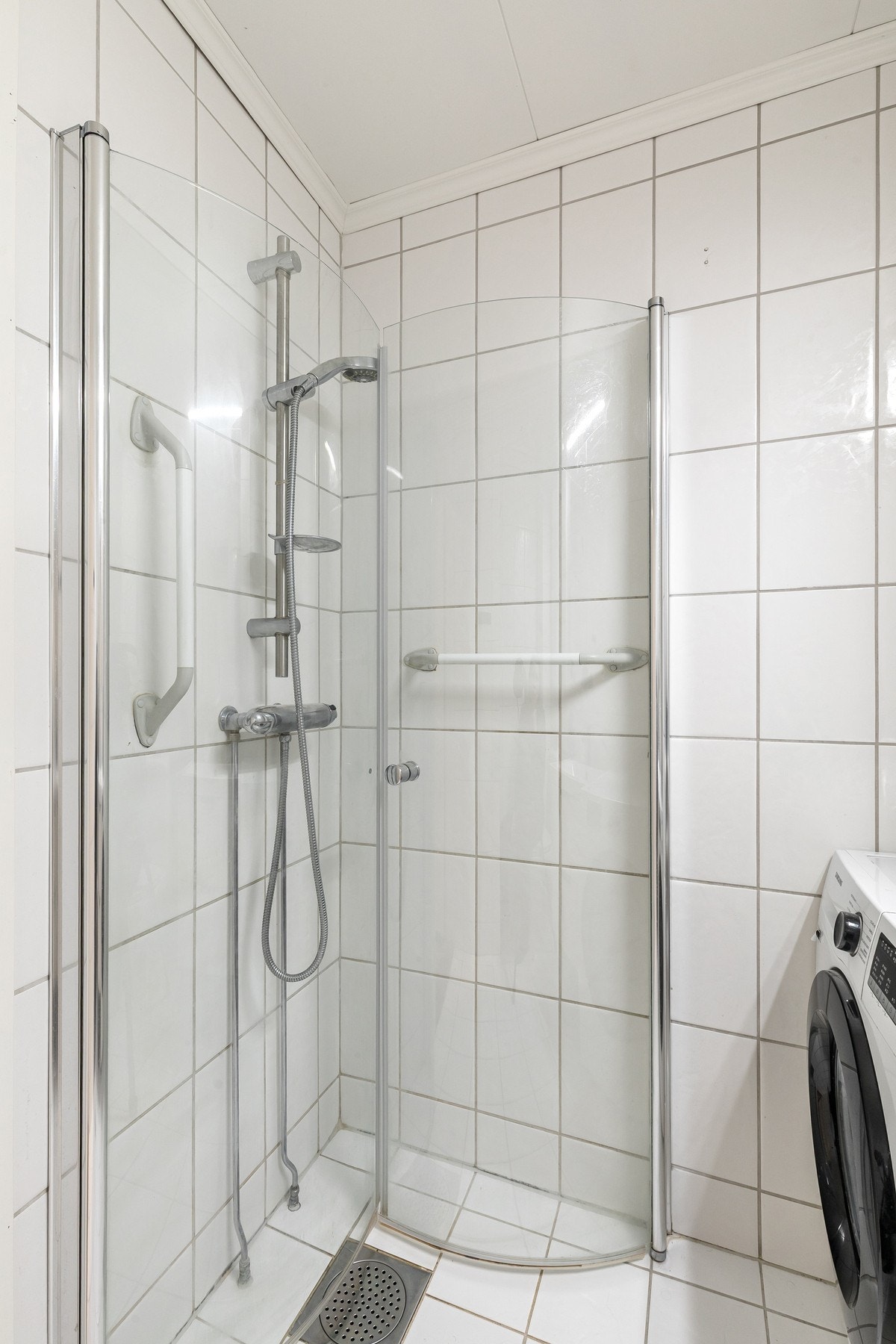 Badet er utstyrt med dusjhjørne med innfellbare glassdører, noe som utnytter plassen godt. Galleribilde