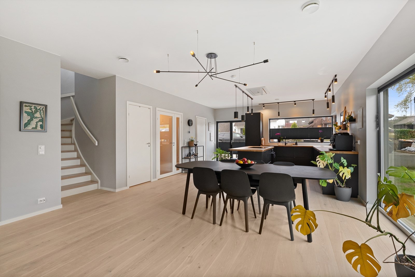 Stuen er romslig og gir plass til både spisebord og flere sittegrupper. Trappen opp til andre etasje er en malt tretrapp med furutrinn. Galleribilde