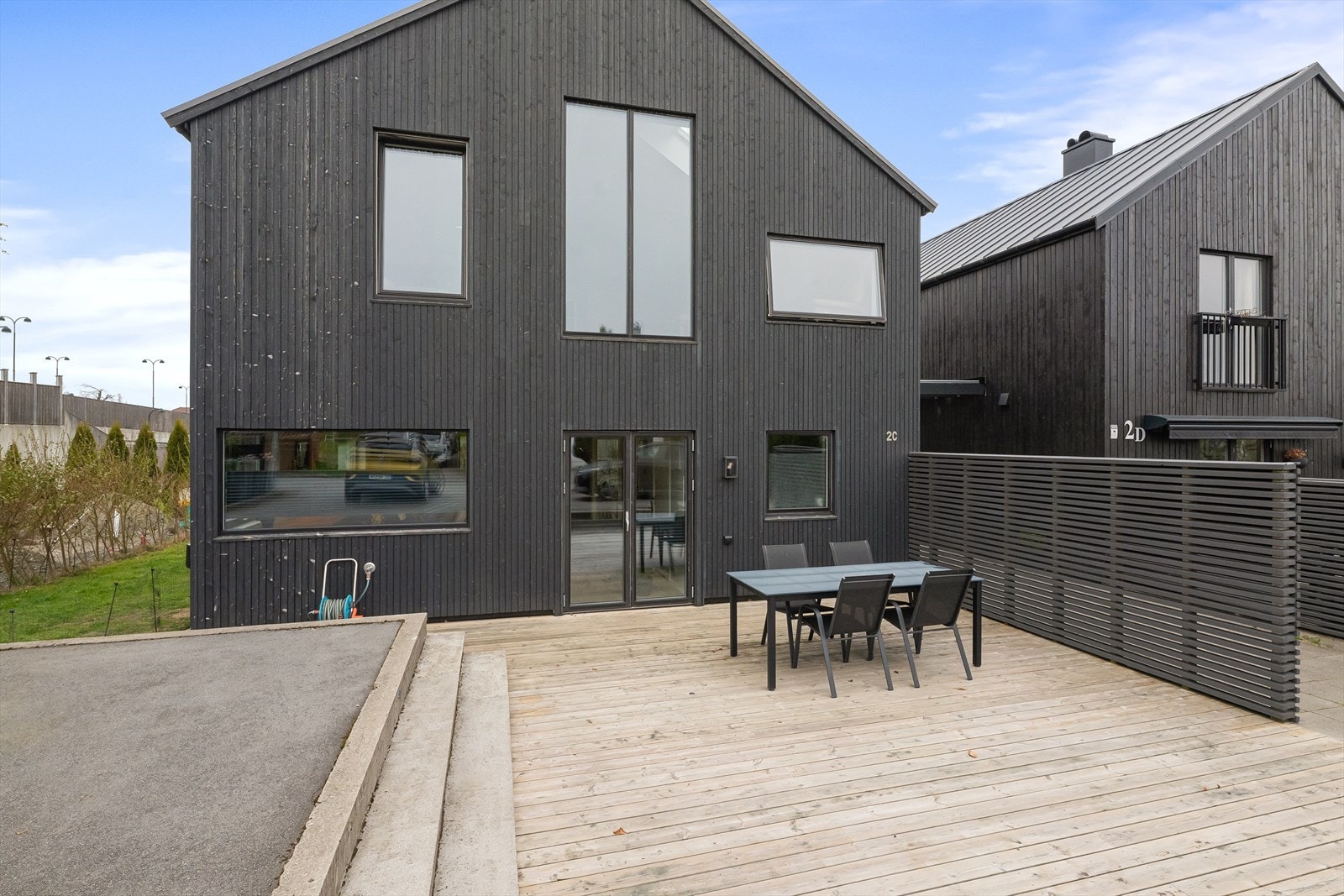 En moderne familiebolig fra 2020, bygget etter TEK17-standarden. Fasaden har stående bordkledning som gir et stilrent uttrykk. Galleribilde