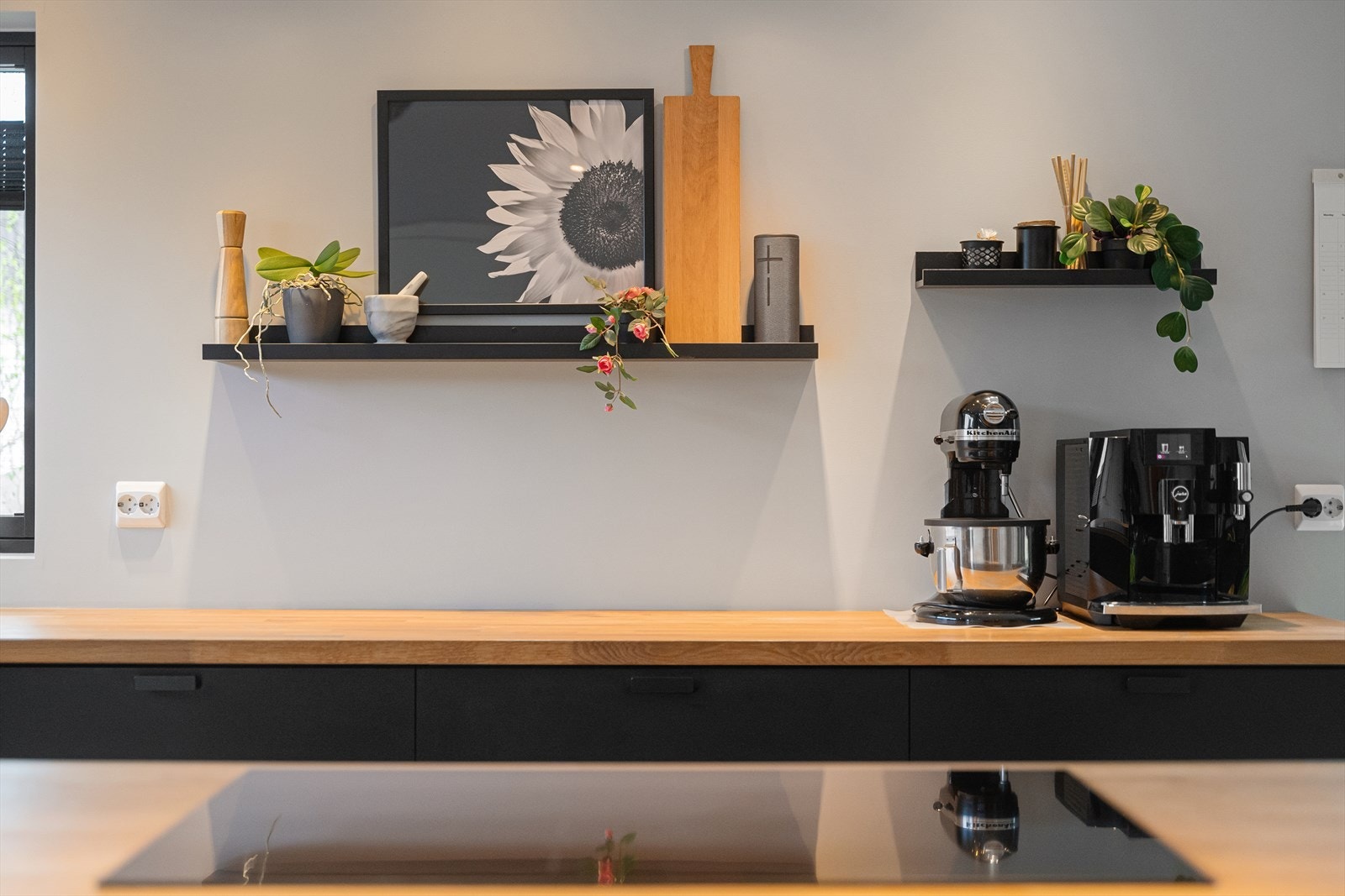 Benkeplaten i heltre gir en varm og taktil kontrast til de sorte frontene. Galleribilde