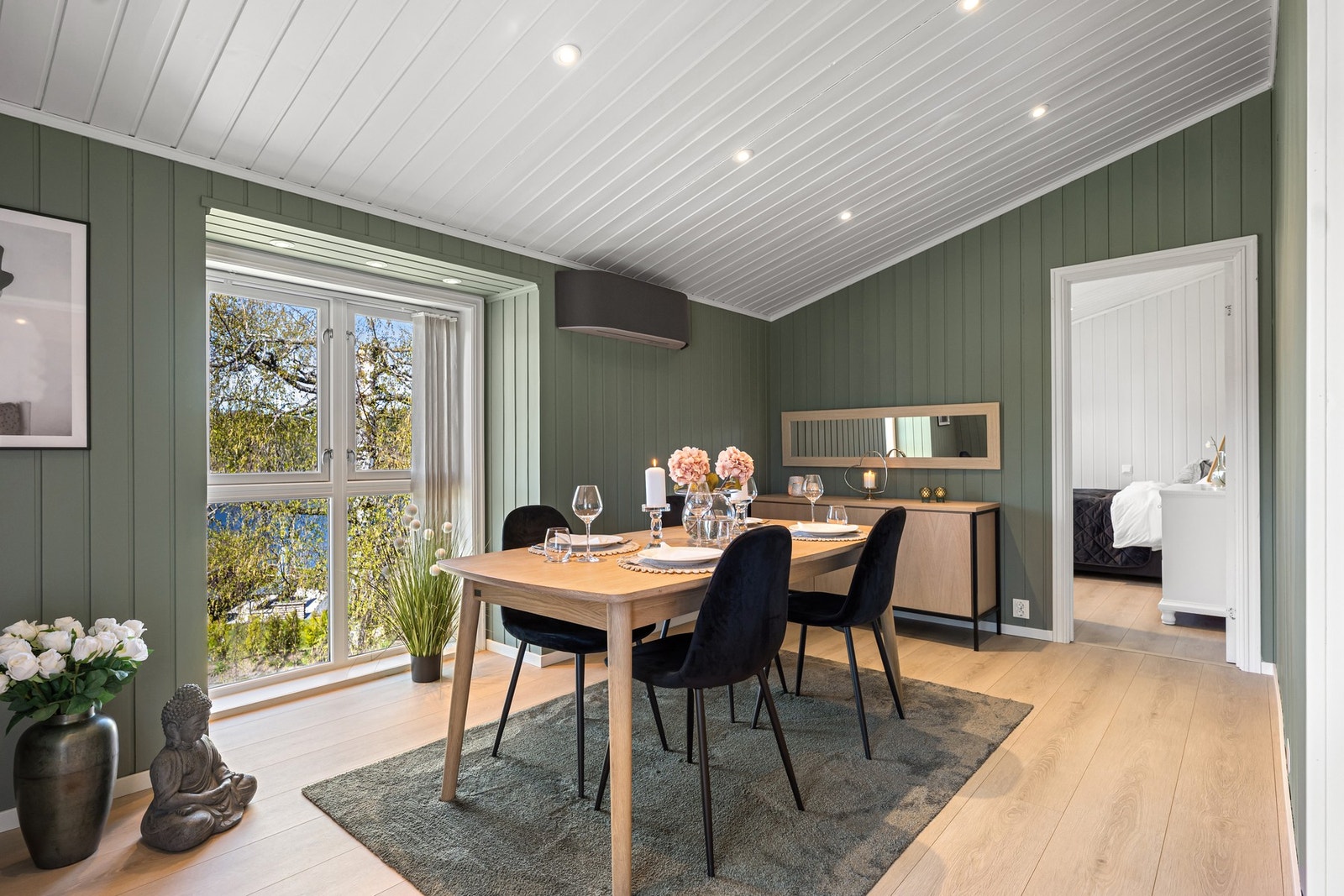 Karakterfull spisestue med grønnmalte trepanelvegger, hvit himling med downlights og direkteutgang til balkongen. Galleribilde