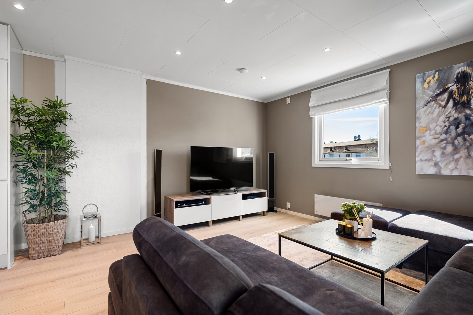 Stuen sett fra sofaen - en varm og innbydende atmosfære med naturlig siktlinje mot kjøkkenet. Galleribilde