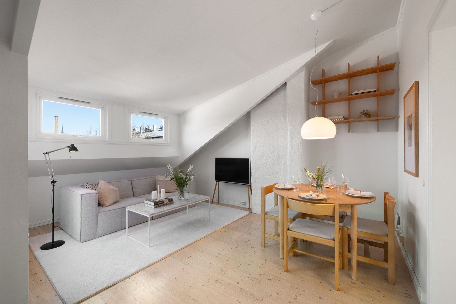 Åpen stue- og kjøkkenløsning med naturlige soner for sofagruppe og spiseplass Galleribilde