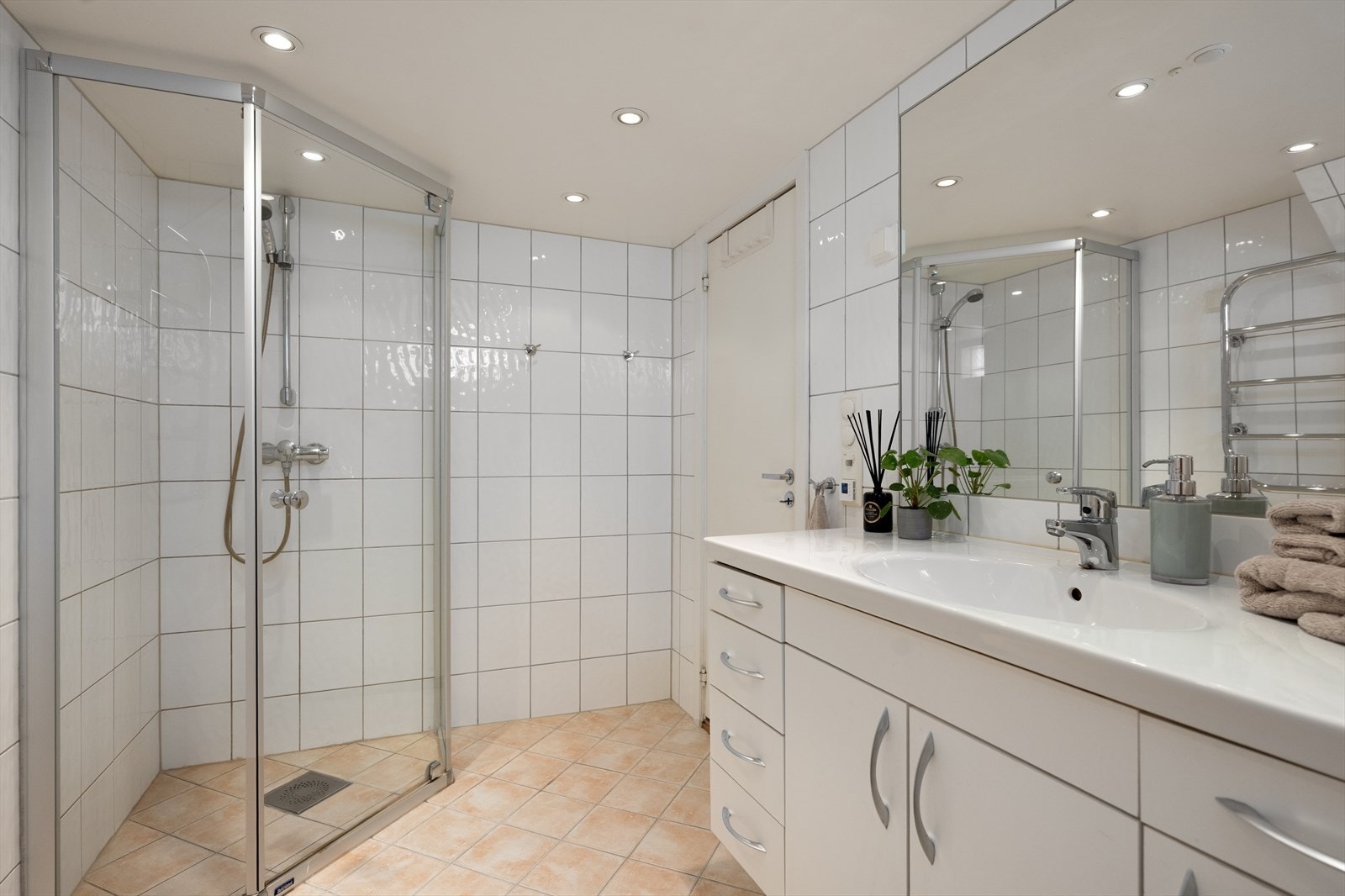 Badet har dusj med faste felt og dør i herdet glass, samt elektrisk avtrekksvifte. Galleribilde