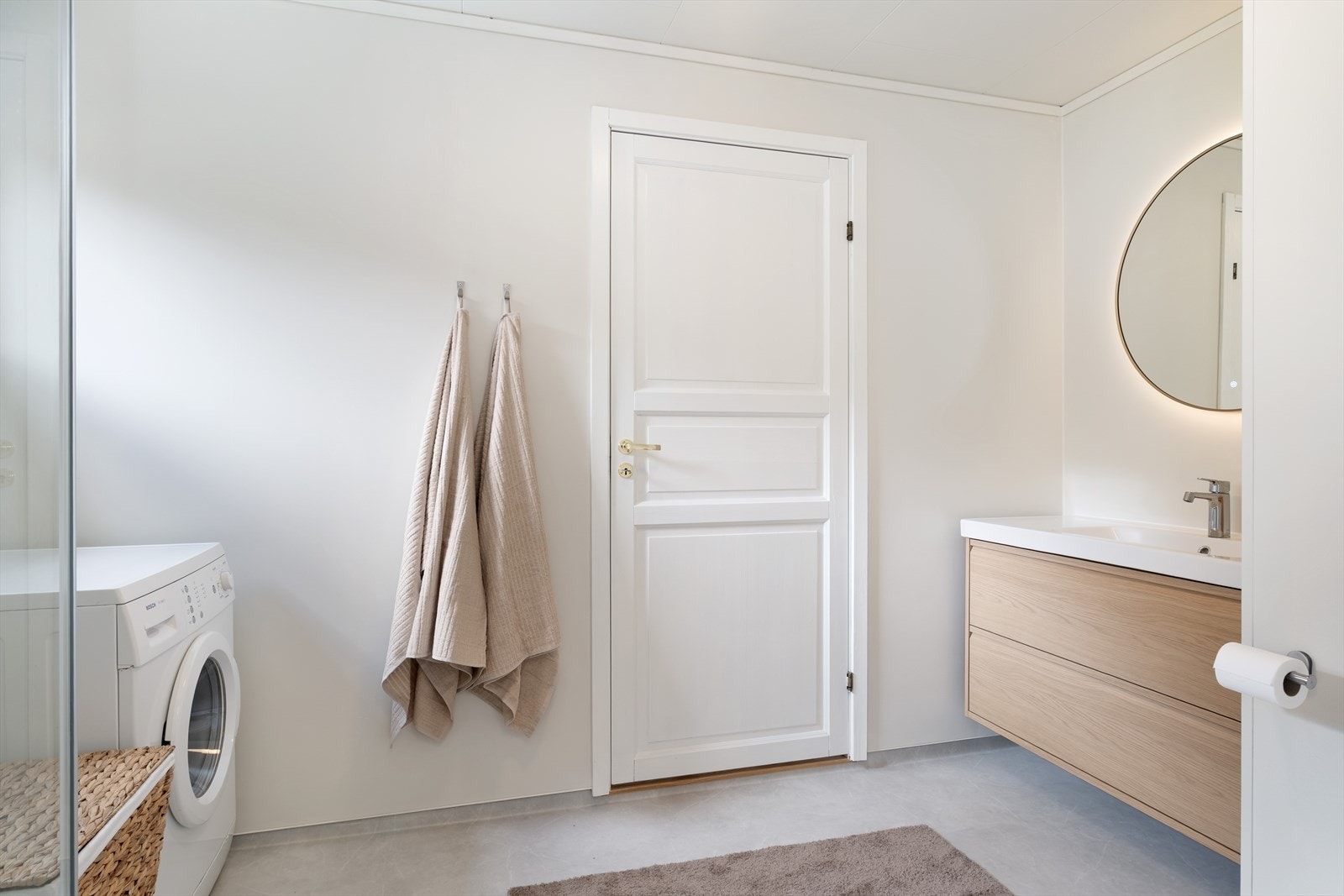 Badet er innreia med servant med skuffeseksjon, dusj og toalett, og har oppplegg for vaskemaskin. Videre dør ut til entré. Galleribilde