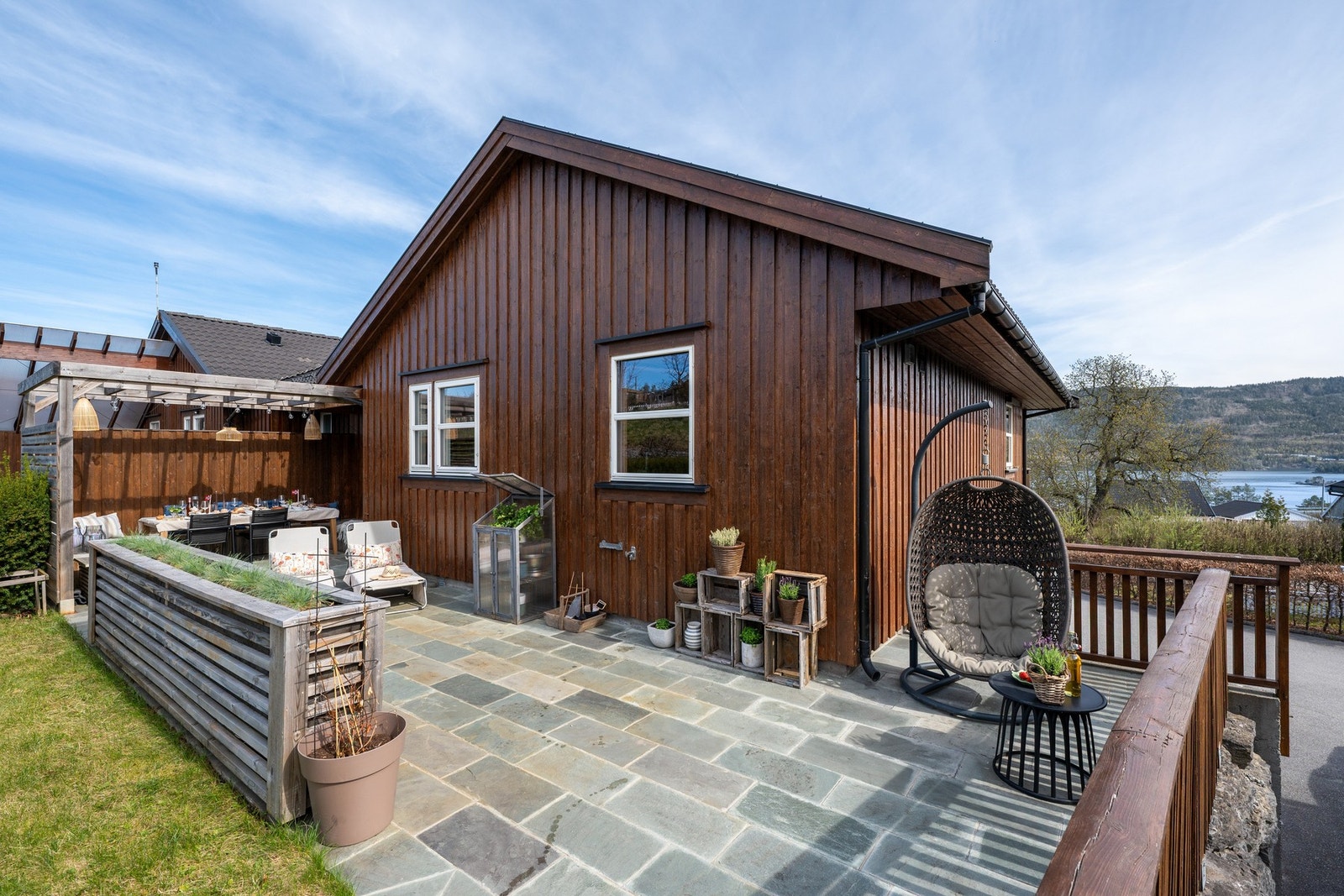 På baksiden finner du en stor terrasse og hage - perfekt for familien. Galleribilde