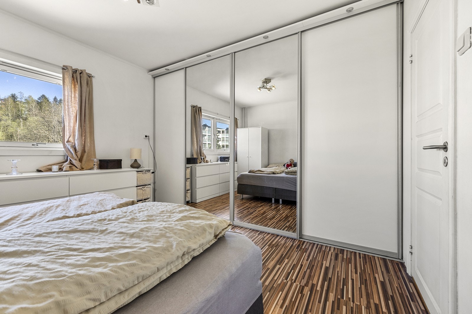 En stor skyvedørsgarderobe med speilfronter gir rikelig med oppbevaringsplass. Galleribilde