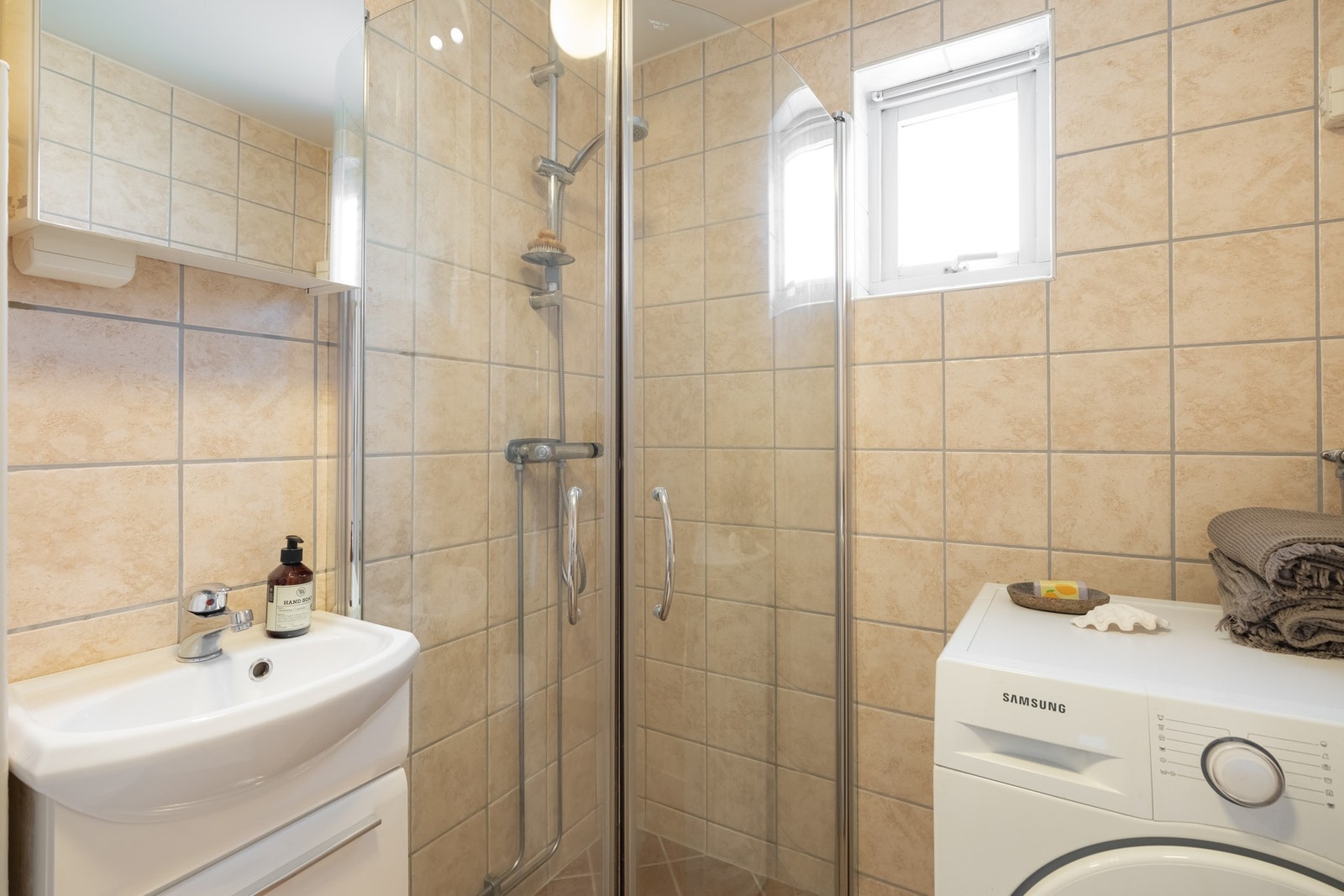 På badet er det naturligvis vannbåren gulvvarme. Badet er utstyrt med skap med glatte fronter, servant, vegghengt toalett og dusj med innfellbare dusjdører. Galleribilde