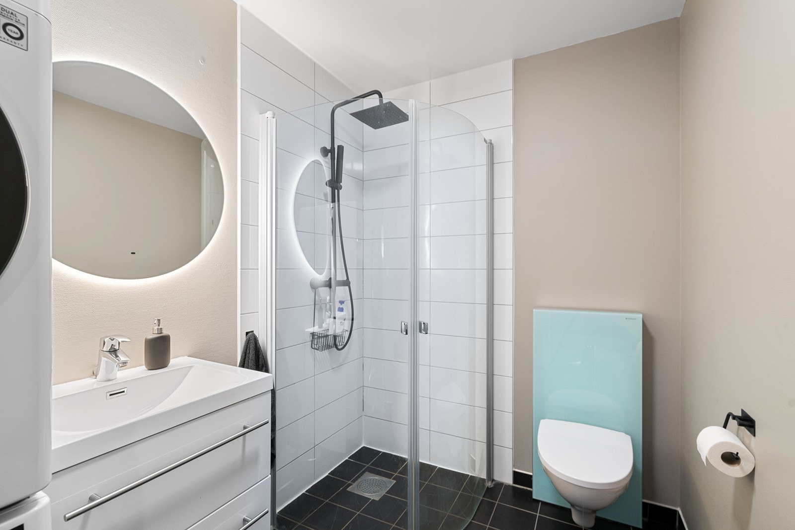 Badet er funksjonelt innredet med toalett, dusj, servant og opplegg for vaskemaskin. Galleribilde