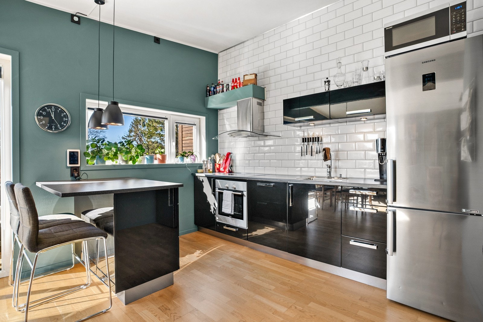 Kjøkkenet er innredet med moderne slette fronter i svart farge og laminat benkeplate. De fleste hvitevarene er integrerte. Det er også montert fliser på ene veggen som gir et moderne utrykk til kjøkkenet. Galleribilde