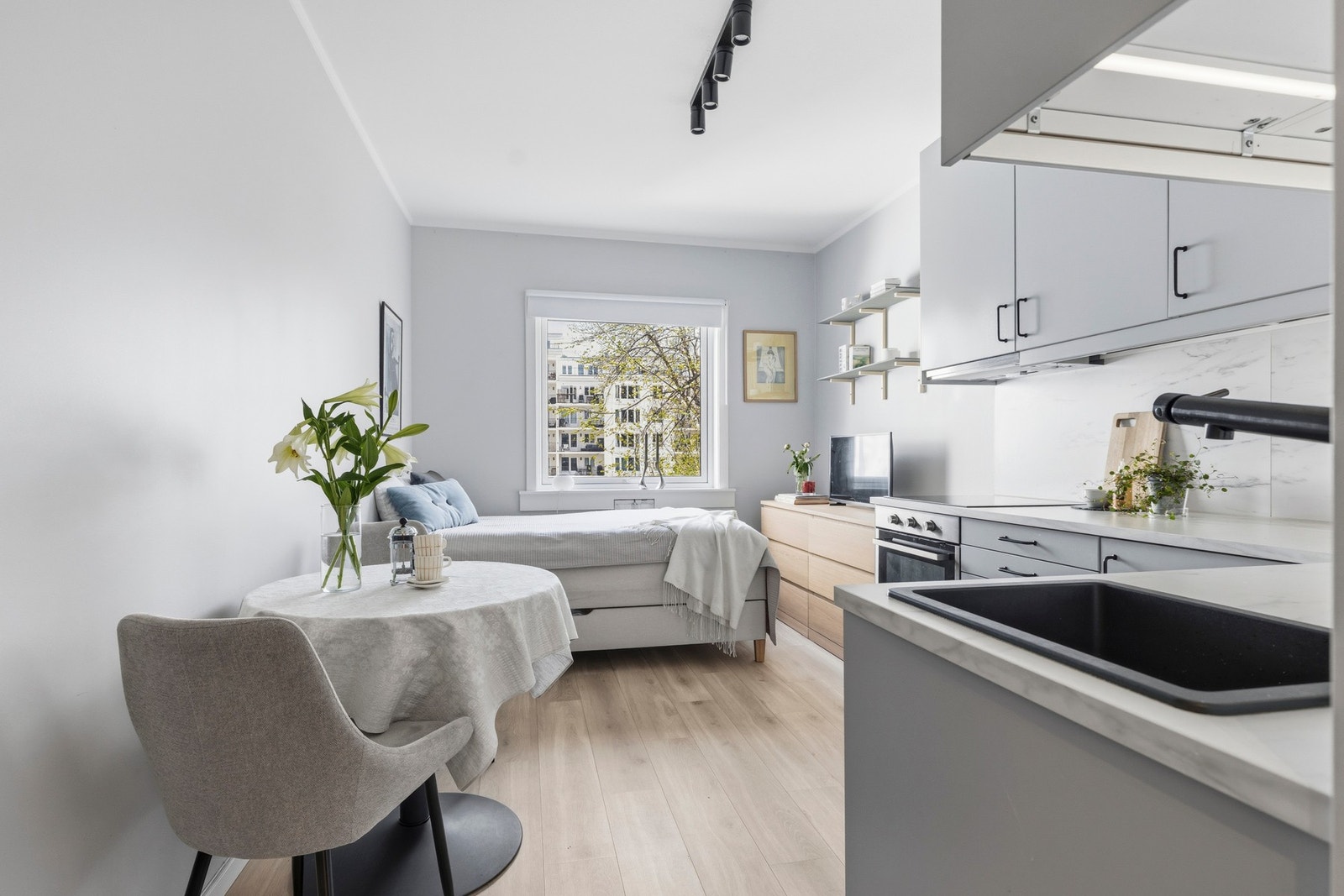 Rommet fremstår som lyst og arealeffektivt, med en åpen løsning som kombinerer stue, soveplass og kjøkken på en funksjonell måte. Galleribilde