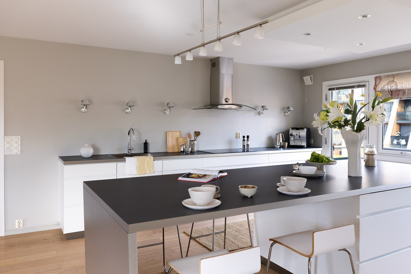 Den 80 cm brede induksjonstoppen og avtrekkshetten med kullfilter gjør matlagingen effektiv. Galleribilde