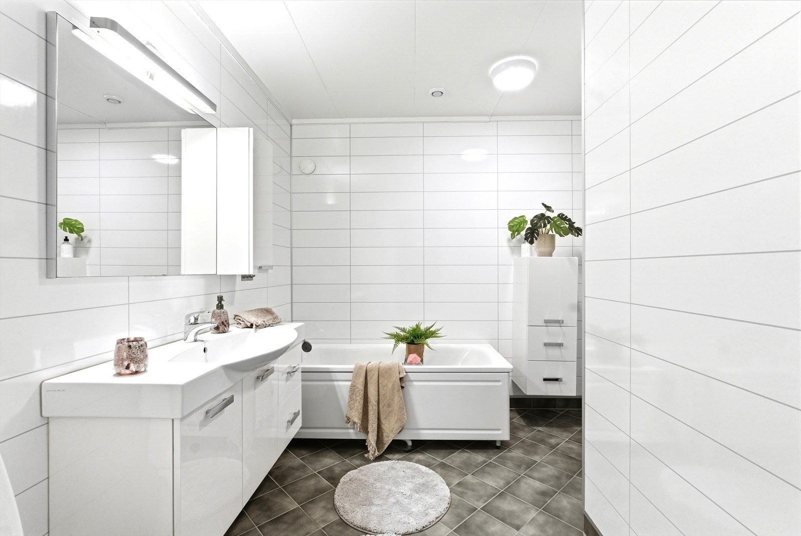 Lyst og romslig bad innredet med både dusjkabinett og badekar, samt wc. Galleribilde
