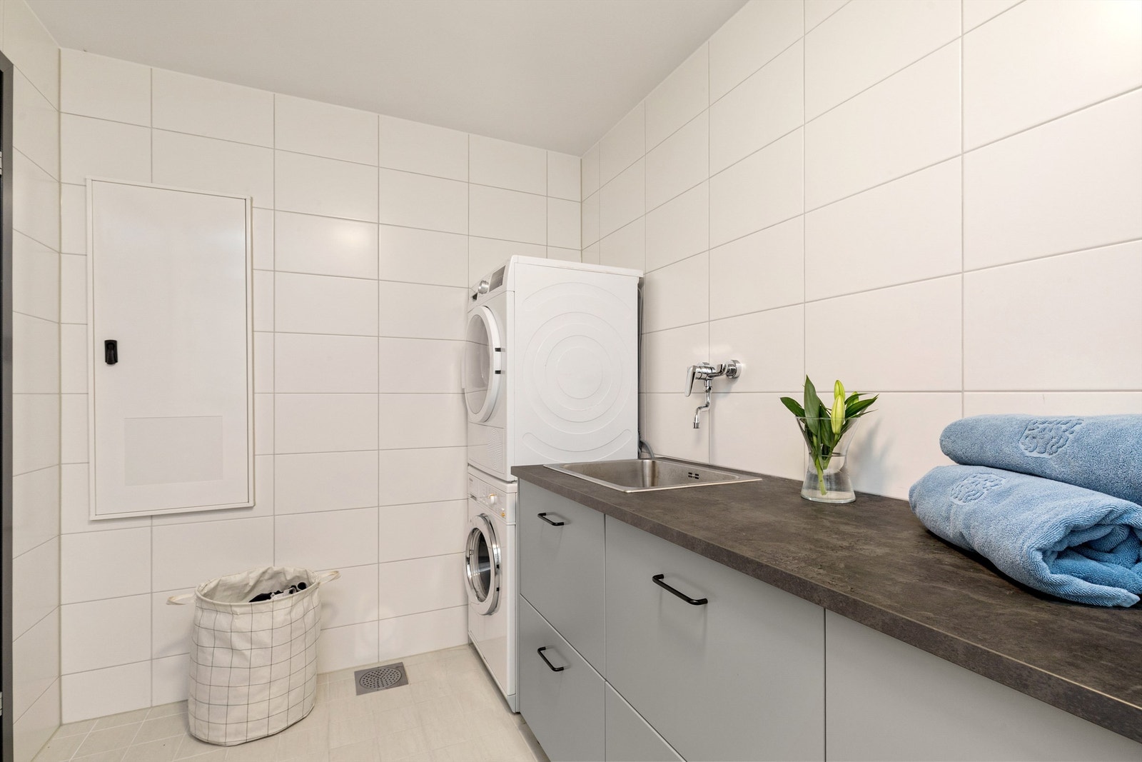 Opplegg for vaskemaskin og tørketrommel samt praktisk innredning med utslagsvask. Galleribilde