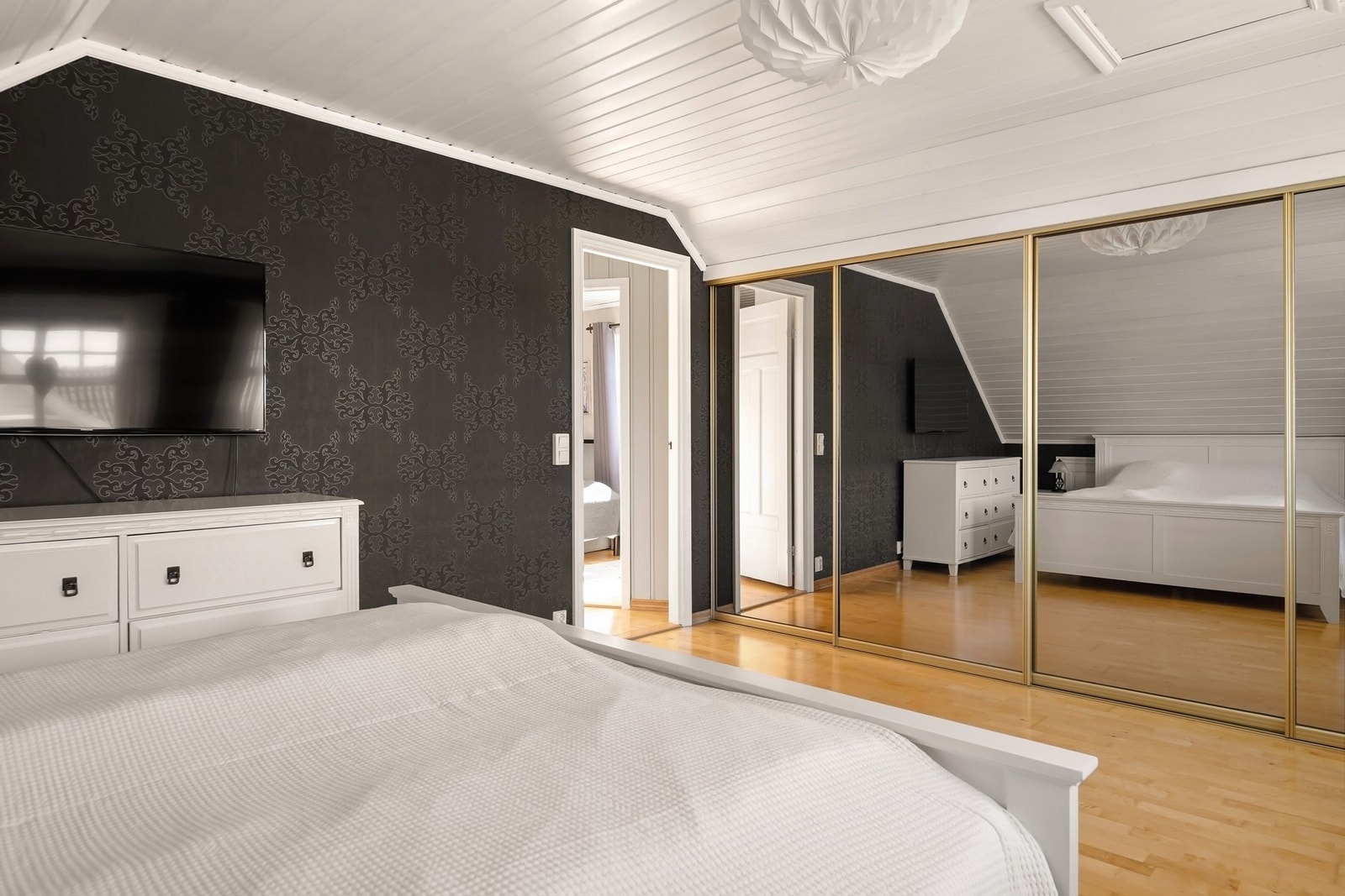 En stor skyvedørsgarderobe med glassfronter gir rikelig med oppbevaringsplass Galleribilde