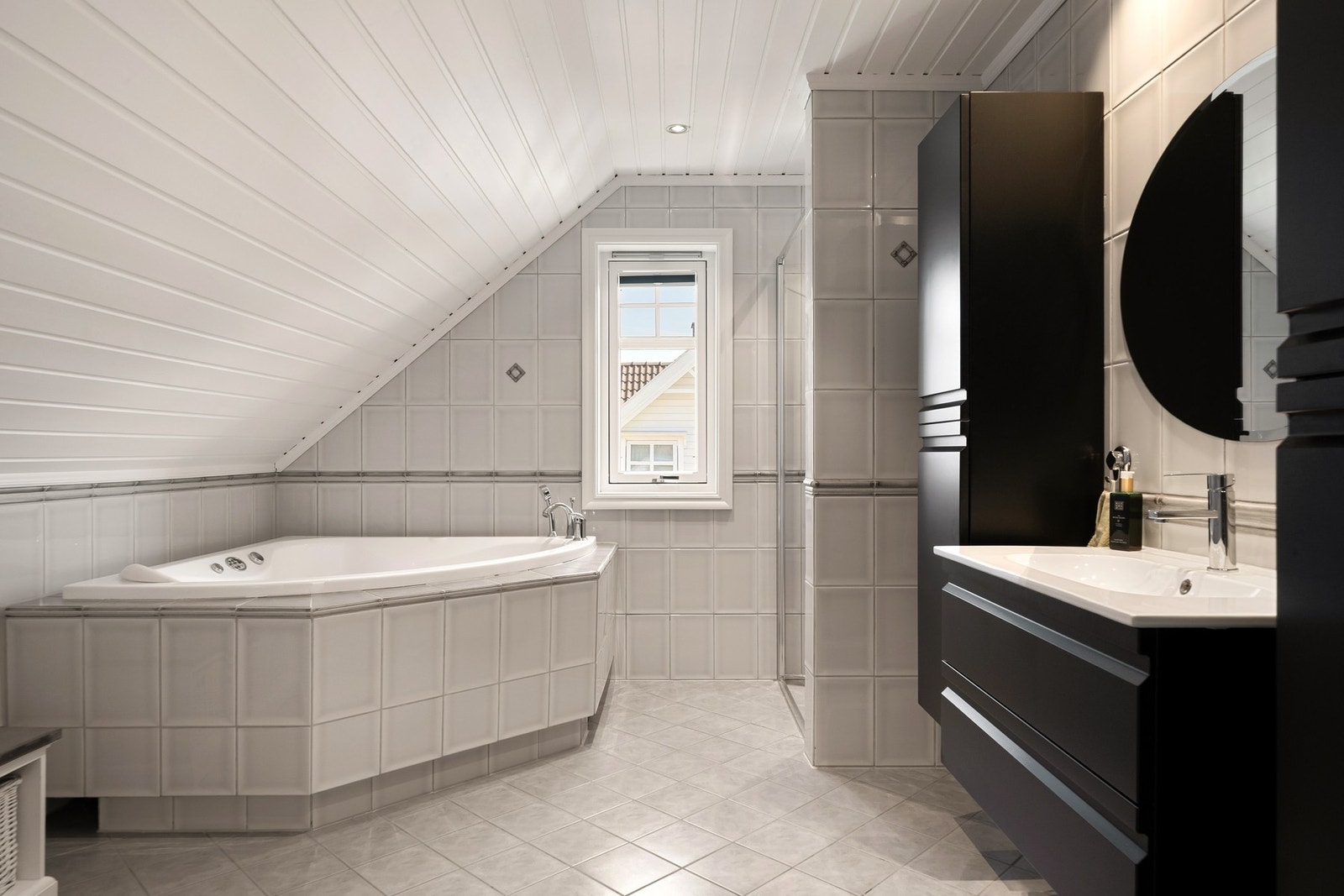 Det er utstyrt med baderomsinnredning, gulvstående wc, innebygd boblebad og dusjhjørne Galleribilde