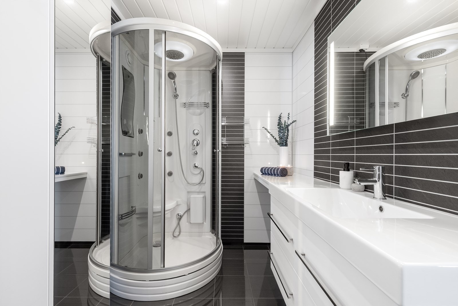 Badet er utstyrt med veggmontert toalett og et praktisk dusjkabinett. Galleribilde