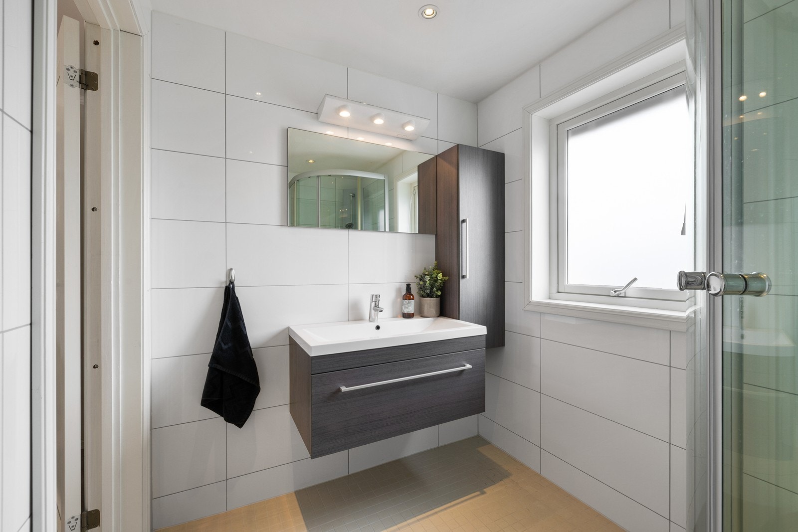 Badet i andre etasje har lyse mosaikkfliser på gulv og klassiske hvite fliser på vegg. Galleribilde