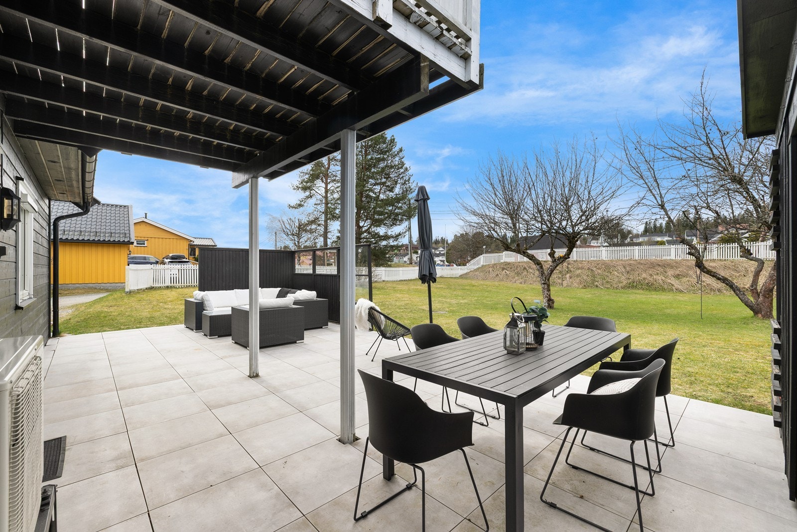 En del av terrassen ligger praktisk overbygget under balkongen, noe som gir en perfekt kombinasjon av solfylte flater og svalende skygge. Galleribilde