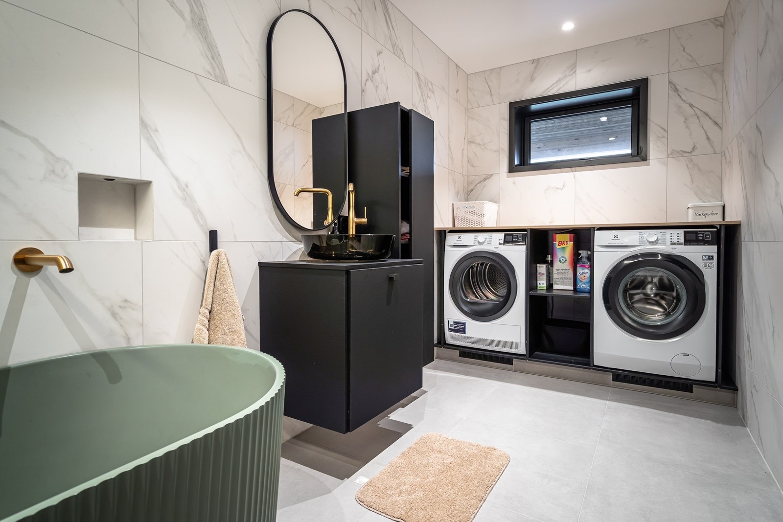 Badet i 1.etasje har flislagte vegger og gulv med gulvvarme, samt opplegg for vaskemaskin og tørketrommel. Galleribilde