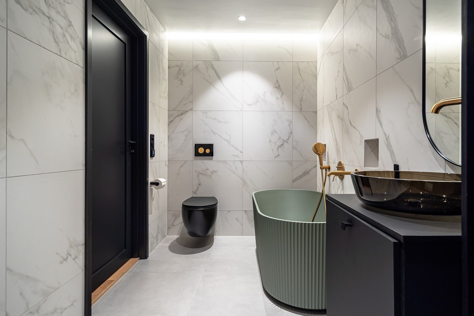 Badet inkluderer et frittsående badekar og vegghengt toalett. Galleribilde