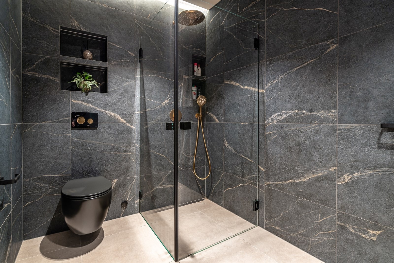 Badet er utstyrt med vegghengt toalett og flislagte vegger. Galleribilde