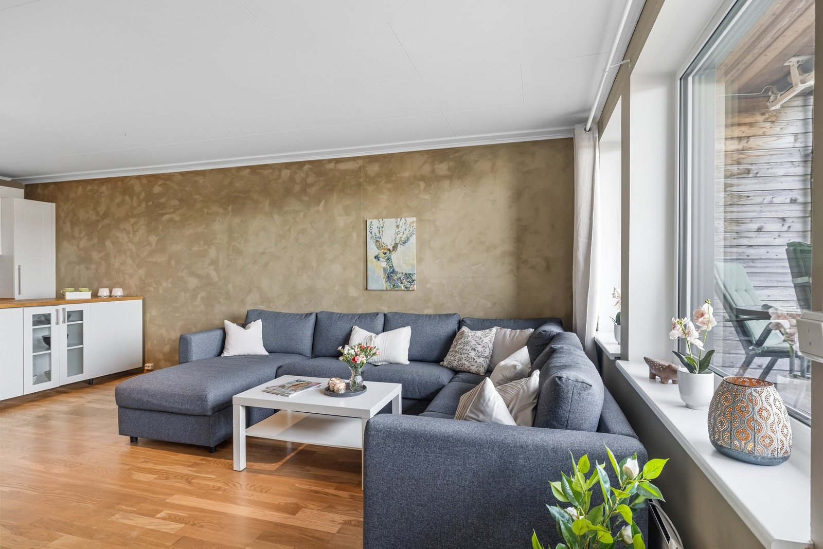Store vindusflater slipper inn rikelig med naturlig lys og bidrar til en luftig atmosfære, samtidig som utgangen til verandaen gir en naturlig forlengelse av oppholdsrommet. Galleribilde
