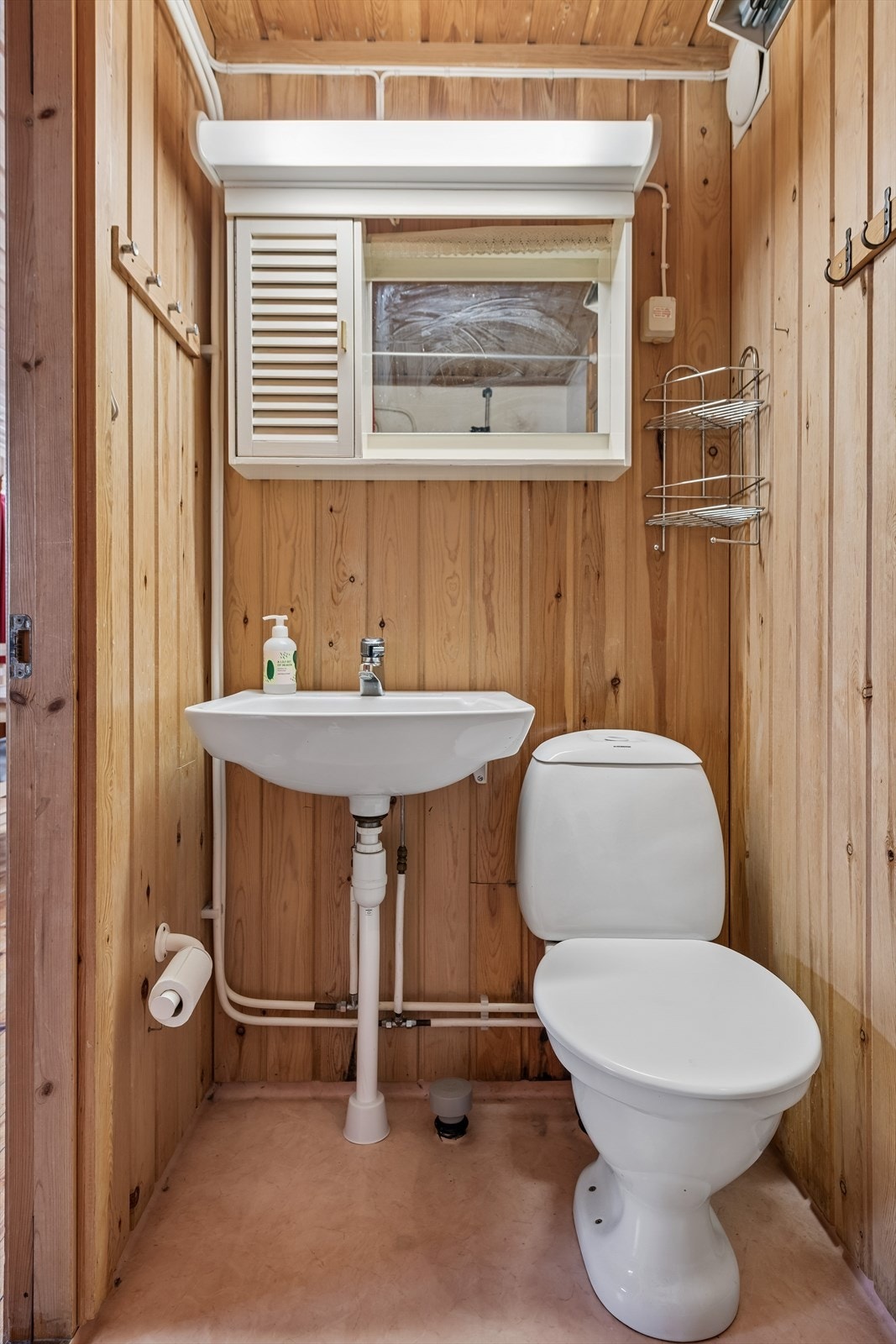 Badet er av eldre årgang og har behov for oppgradering. Toalett, vegghengt servant og dusj. Galleribilde