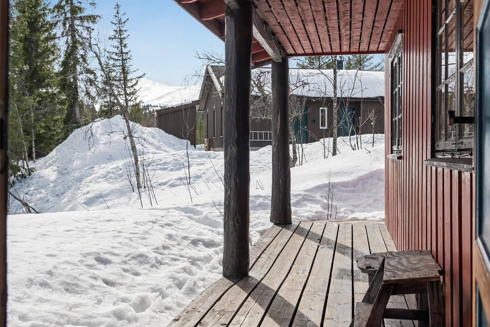 Overbygget inngangsparti og svalgang med terrassebord av impregnert tre. Galleribilde