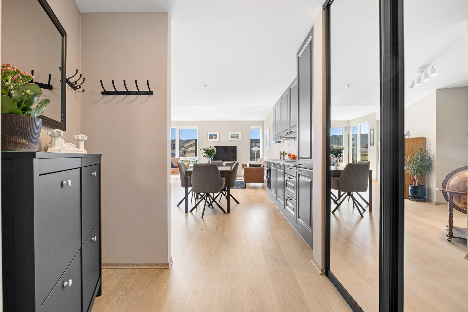 Lys og innbydende entrè med skyvedørsgarderobe. Galleribilde