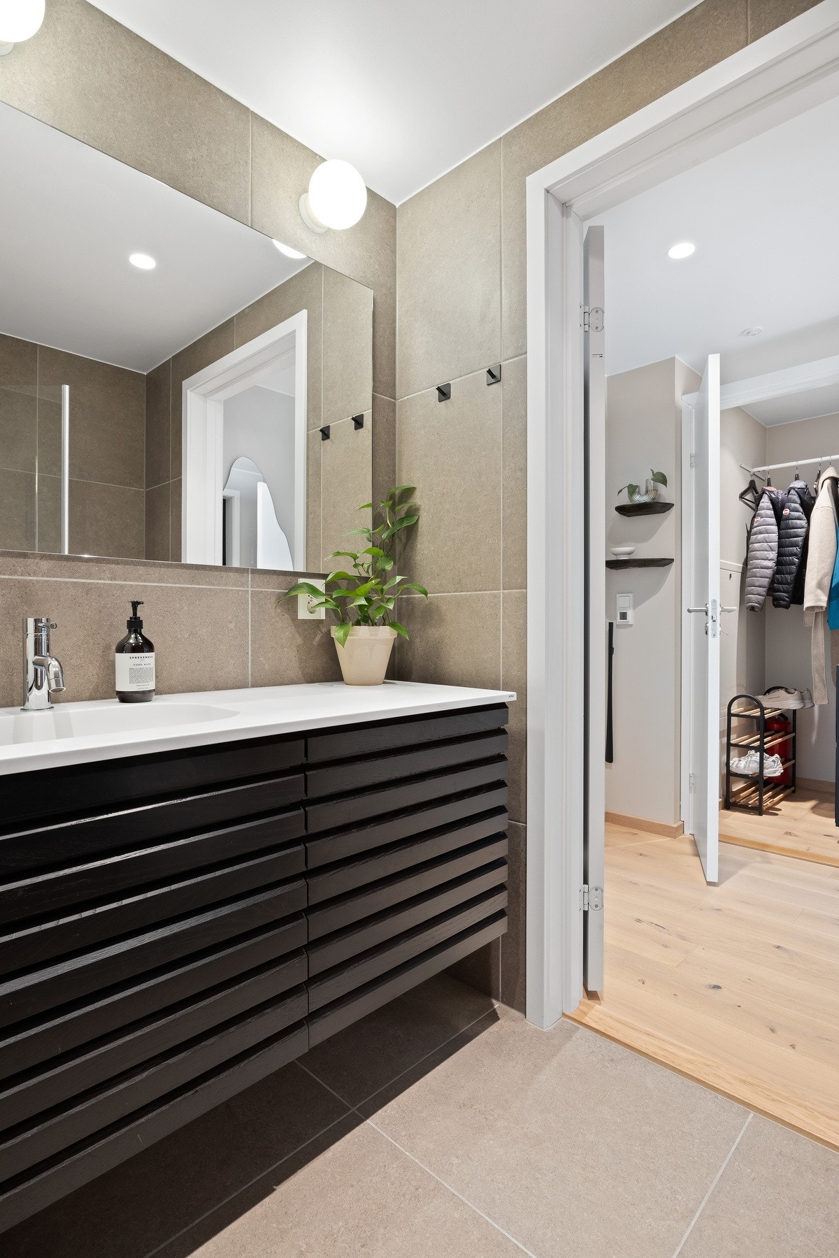 Badet har moderne fliser og servantløsning, med adkomst til en praktisk garderobe. Galleribilde