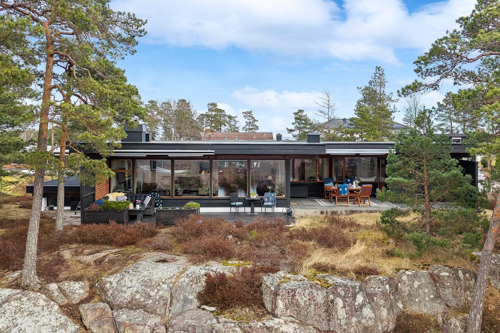 Både den stenlagte terrassen og terrassen med tredekke er utstyrt med markise Galleribilde