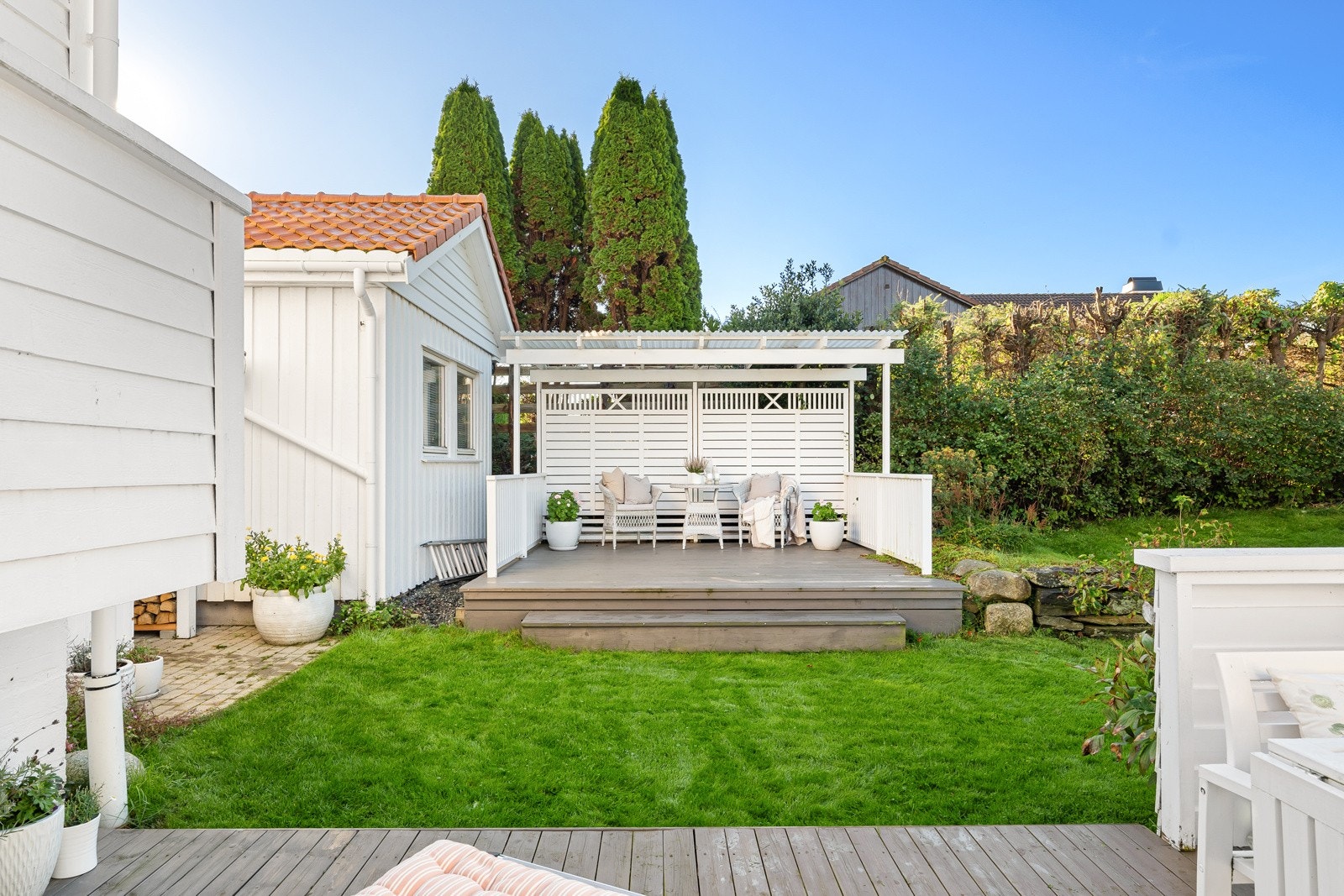 Like ovenfor hagestuen er det en svært hyggelig og skjermet uteplass med pergola, som skaper en lun og innbydende uteplass. Galleribilde