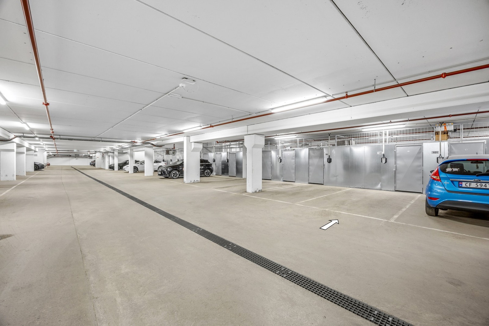 Leiligheten har fast parkeringsplass i felles garasjekjeller (nr. 100 ifølge selger). Det er tilrettelagt for montering av elbillader, men selve ladeboksen er ikke installert. Galleribilde