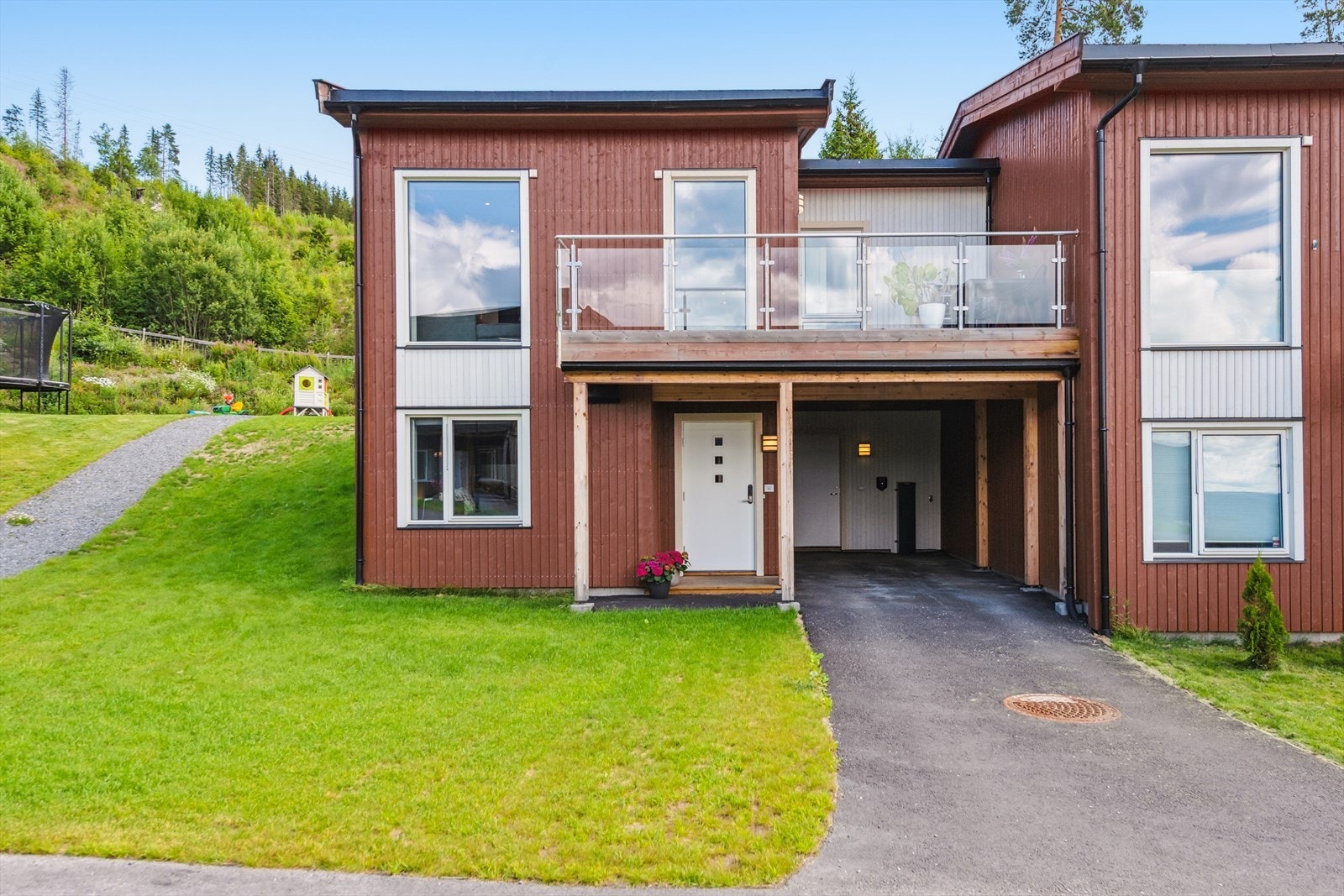 Et trivelig og overbygget inngangsparti ønsker deg velkommen hjem, og gir et godt førsteinntrykk. Carport og utebod ved inngangsparti. Galleribilde