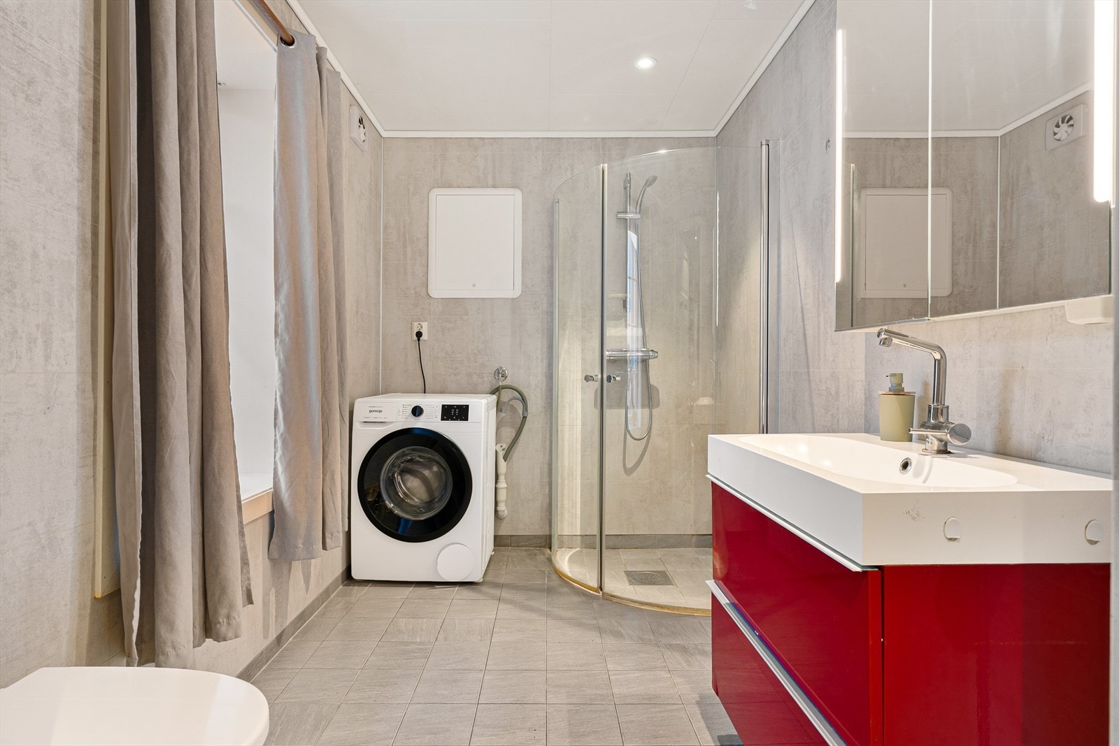 Romslig baderom fra 2016 på ca. 5,2m². Badet er innredet med servant og utstyrt med toalett og dusjhjørne. Galleribilde