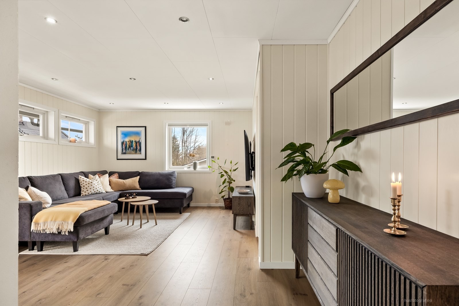 Stuen er delikat og innbydende med 1-stavs laminat på gulv, panel på vegger malt i en dus fargetone. Galleribilde