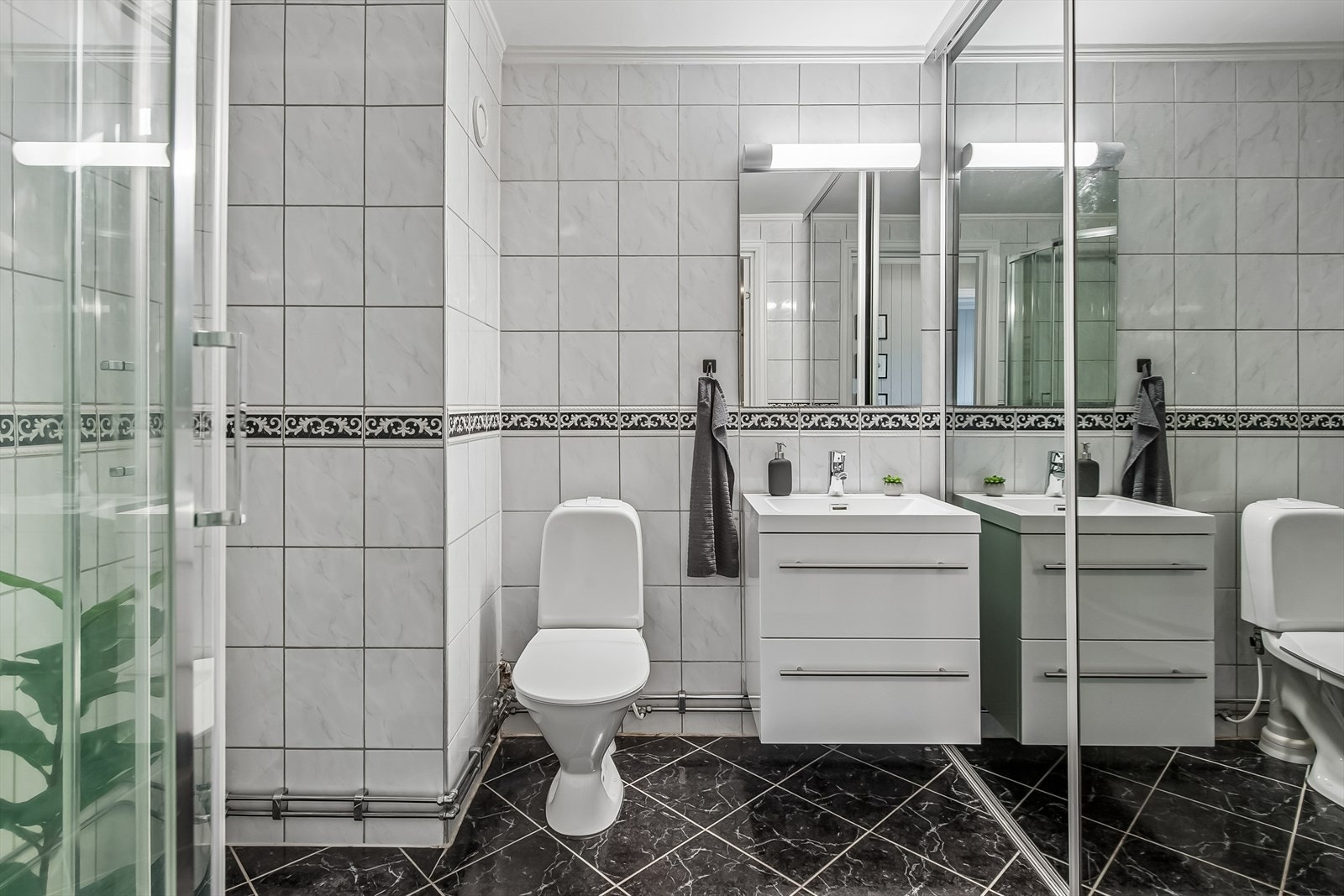 Flislagt og romslig bad med dusjkabinett, wc og opplegg vaskemaskin. Galleribilde