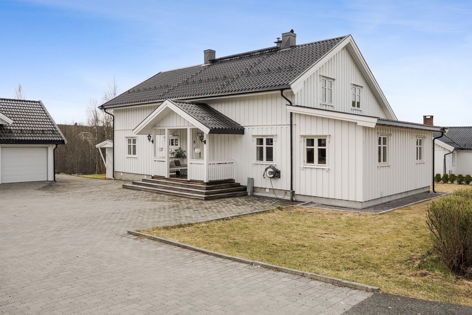 Tomten er pent opparbeidet med belegningsstein i gårdsplassen med kantsteiner. Galleribilde