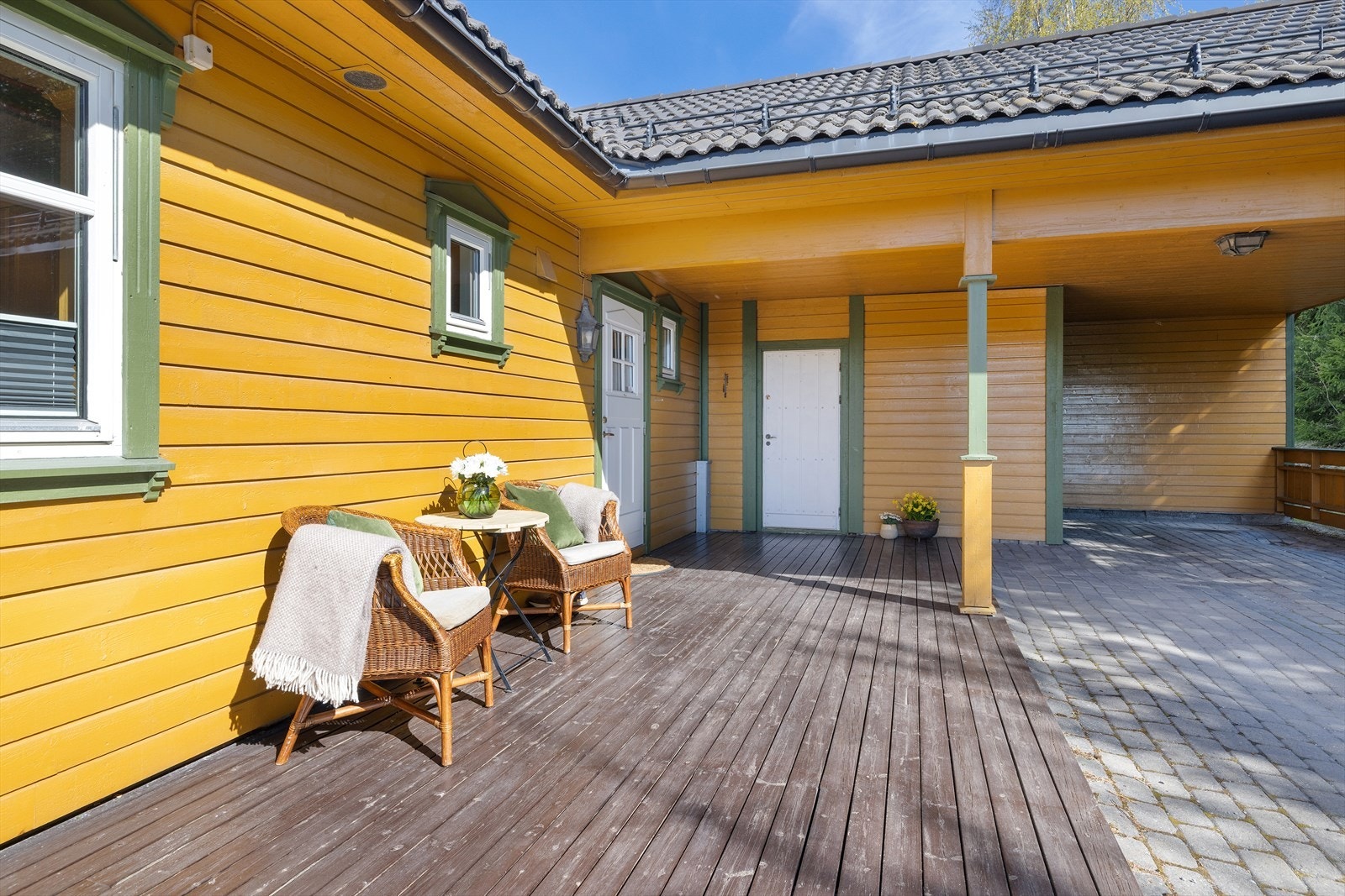 Den delvis overbygde terrasseplattingen ved inngangspartiet gir en lun og usjenert frokostplass. Galleribilde