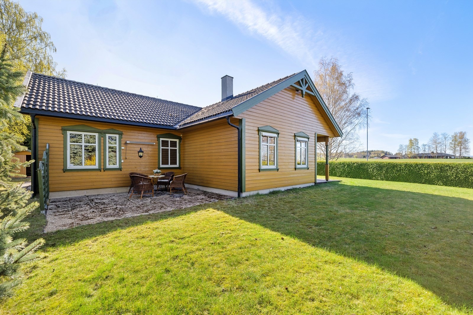 Hagen er opparbeidet med plen og beplantning, og tomten er skjermet med hekk. Galleribilde