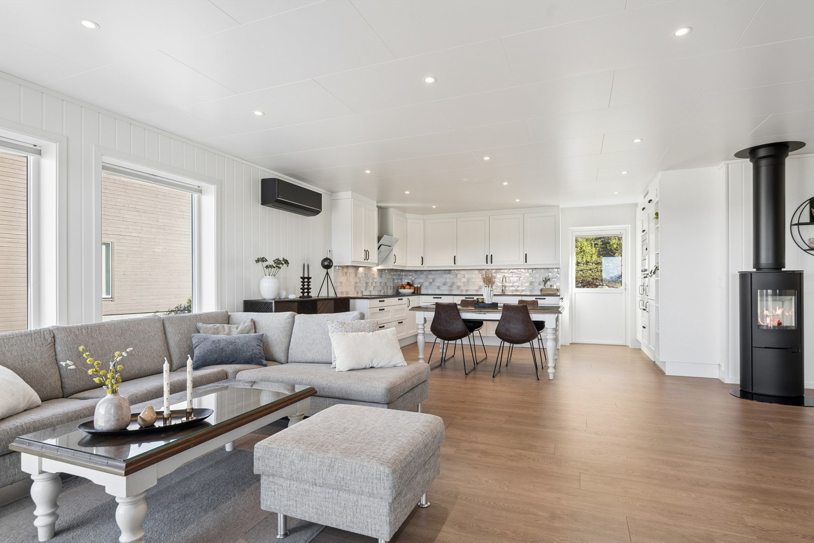 Allrommet har god plass til både sofagruppe og spisebord. Peisovnen er et sentralt element som skaper en lun atmosfære. Galleribilde