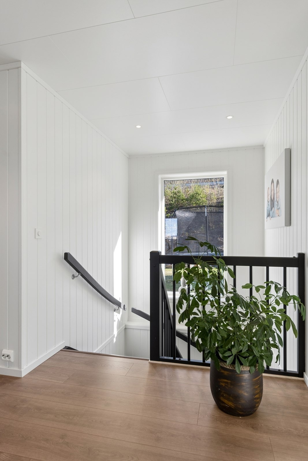 Trapperommet binder boligens to plan sammen. Veggene har malte panelplater og det er downlights i himlingen. Galleribilde