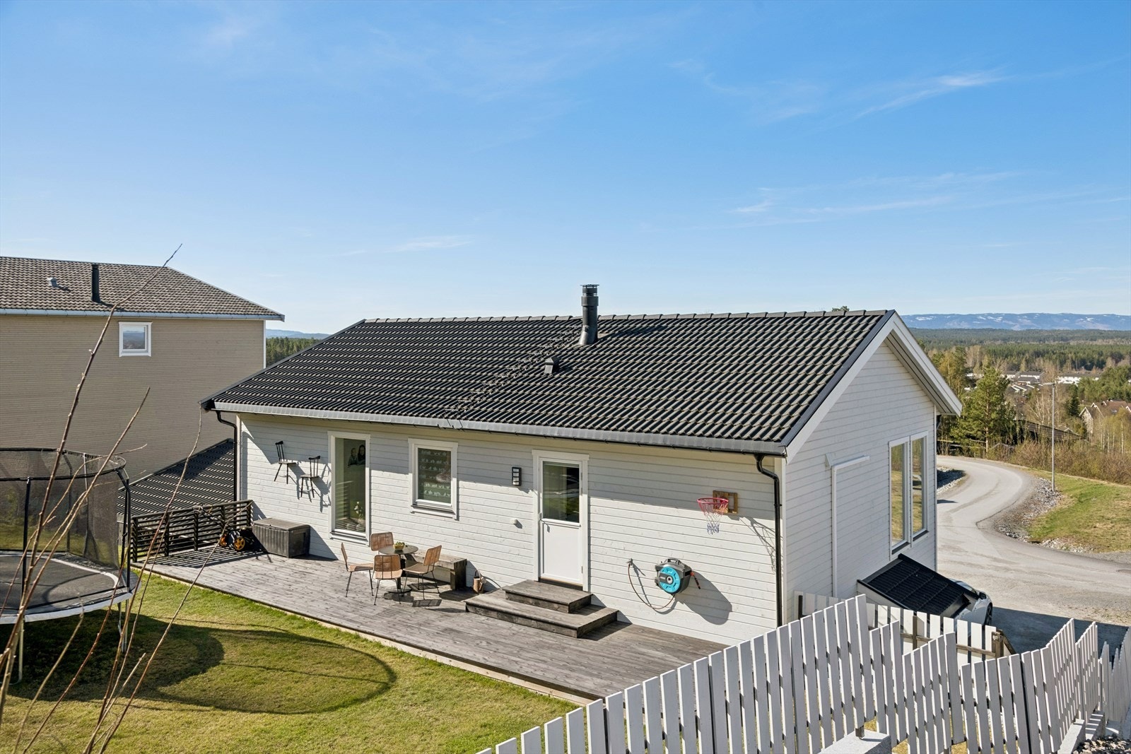 Boligen byr på store uteplasser, inkludert en terrasseplatting på ca. 34 m² med utgang fra kjøkkenet. Tomten er pent opparbeidet med plen. Galleribilde