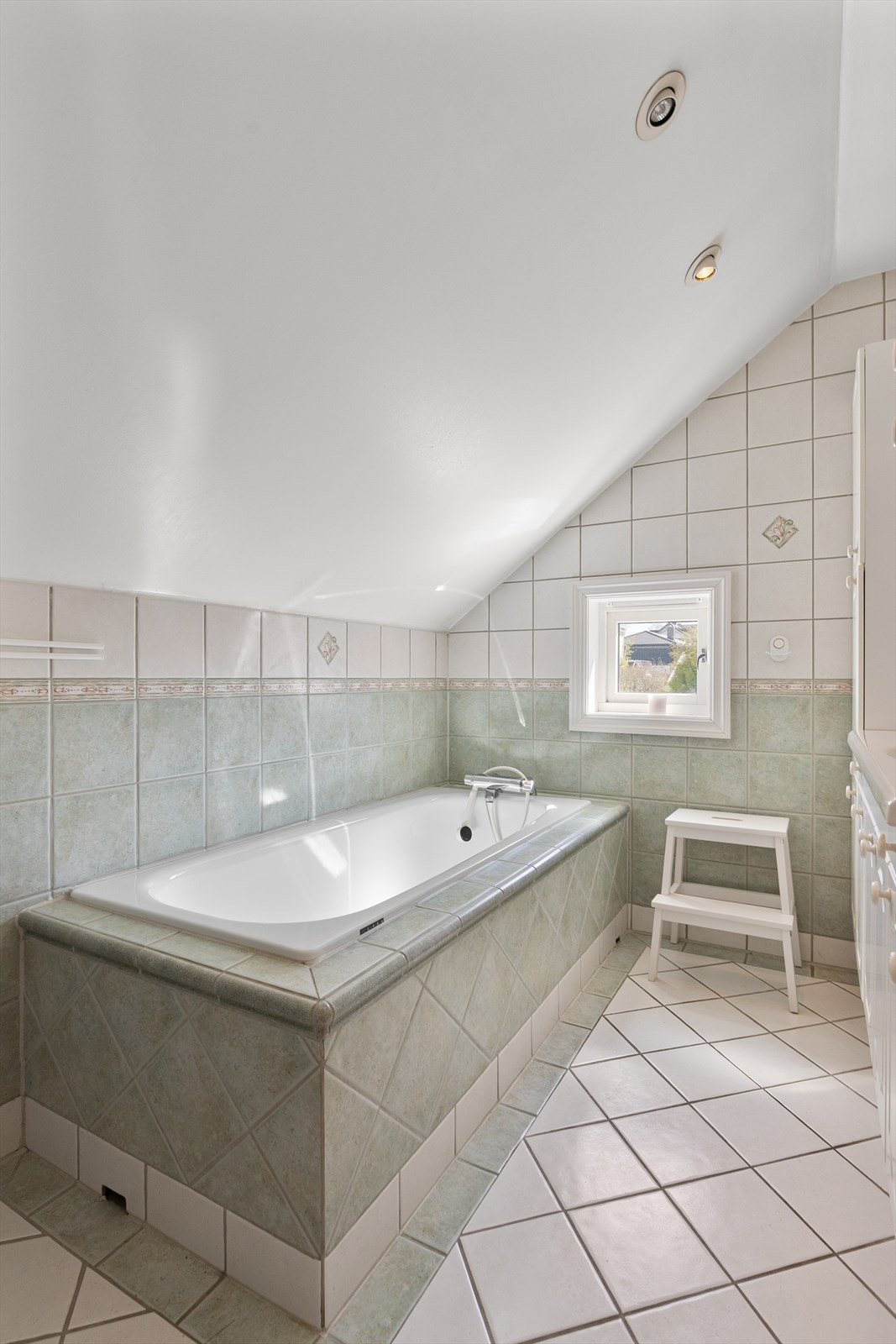 Innmurt badekar med fliser som står i stil til resten av badet Galleribilde