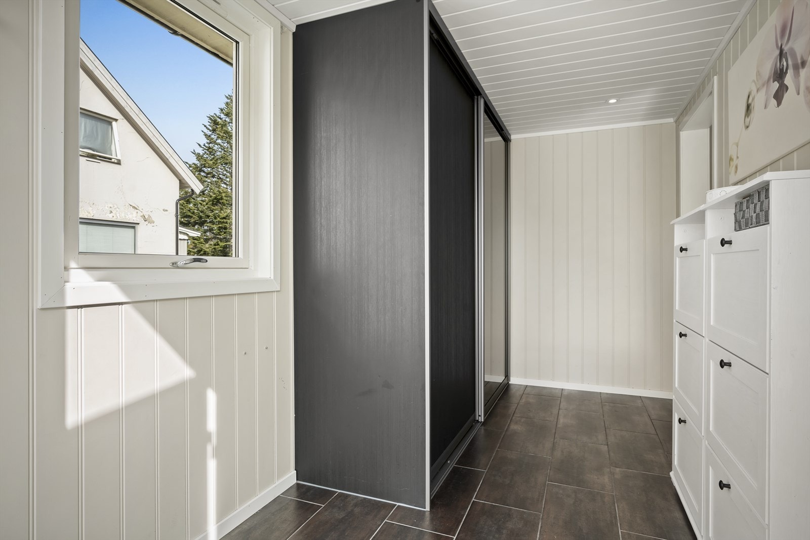 Boligen har en stilren og flislagt entré med god plass til oppbevaring av sko og yttertøy. Galleribilde