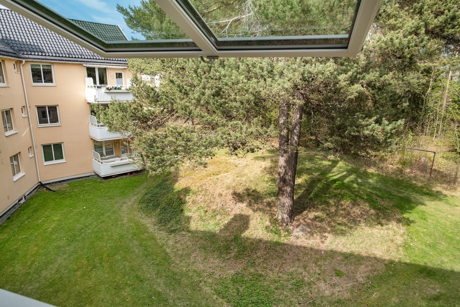 Rommet vender mot et stille og grønt fellesområde Galleribilde
