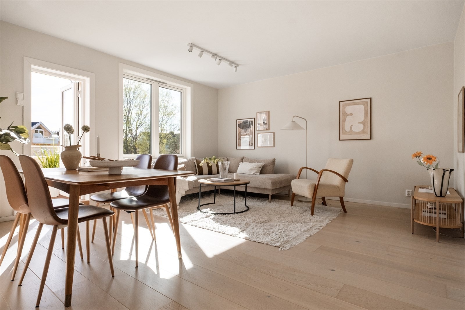 Lys stue med parkett og store vindusflater som gir rikelig med naturlig lys Galleribilde